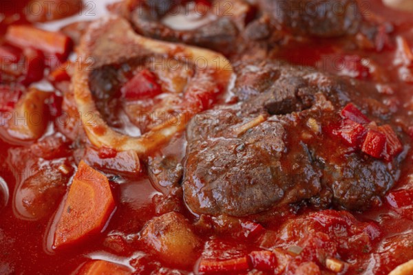 Ossobuco stew with vegetables, knuckle on the bone with new potatoes, in tomato sauce, homemade,