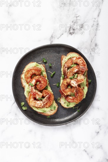 Sandwiches with avocado and caramelized shrimp, micro-greens, breakfast, on a plate, top view,
