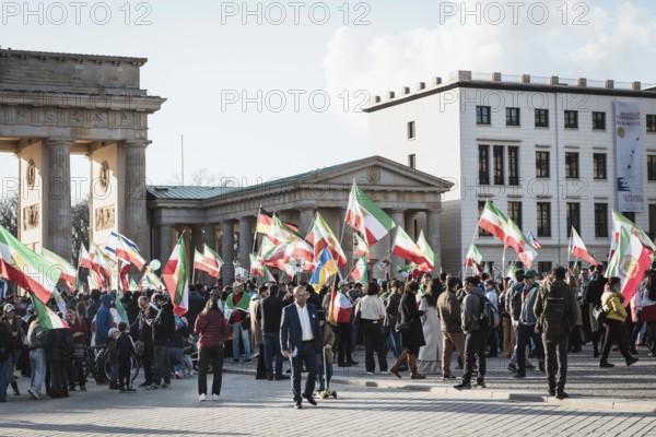 Participants carry Iranian flags from the Pahlavi period and the historic Persian flag during the