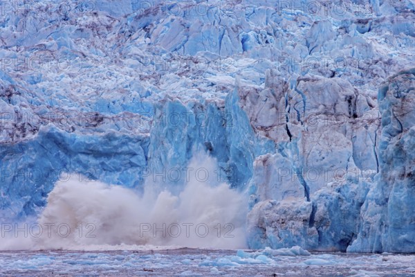 Ice chunk breaking from edge of calving Kongsbreen, marine-terminating glacier debouching into