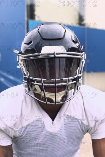 An American football player dressed in full uniform and helmet, ready for action. The scene