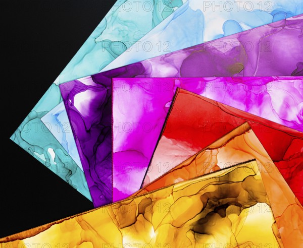 A collection of vibrant abstract ink backgrounds showcasing various vivid colors on paper. Perfect