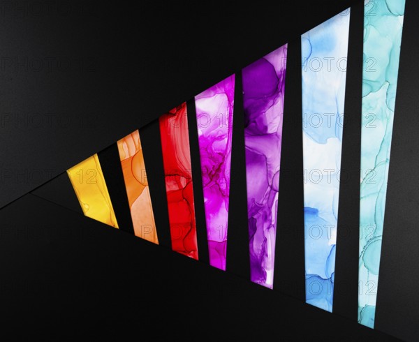 A vibrant geometric pattern with colorful segments on a black background of paper. Each segment