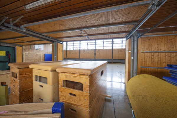Storage room in a gym with stored sports equipment and wooden paneling, Schlehengäu Grund Schule