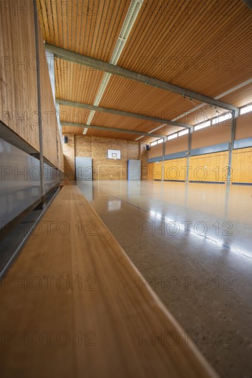 Basketball hall with wooden elements and a quiet, reflective floor area, Schlehengäu Grund Schule