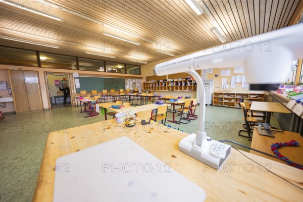 Teacher's desk in a well-lit classroom with blackboards and organized chairs, Schlehengäu Grund