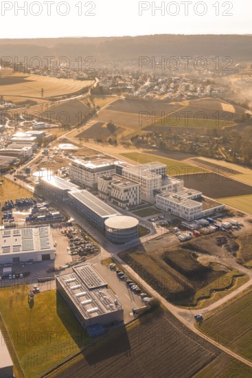 Aerial view of urban landscape in morning light with buildings, parks and fields, new hospital at