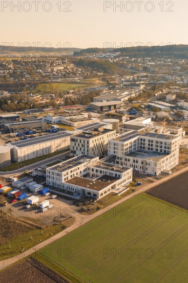 Panoramic view of an urban environment, modern buildings and surrounding fields in morning light,