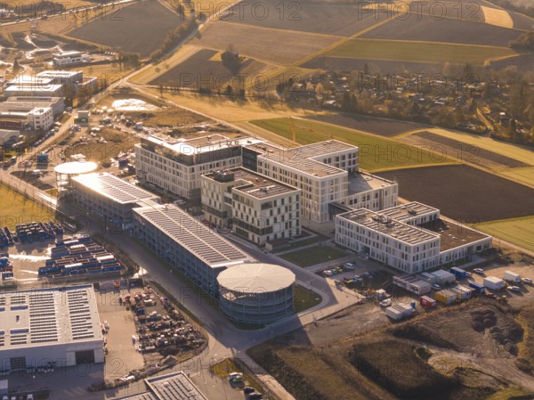 Spacious modern building complexes on the outskirts of a city surrounded by fields, new hospital on