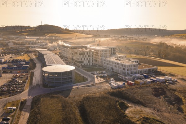 New industrial area with modern buildings and fields in the background at sunrise, new hospital at