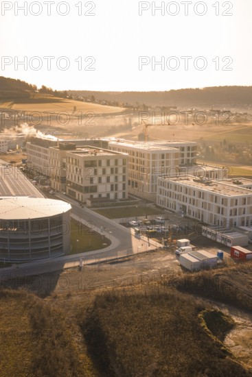 Modern architecture in rural surroundings with small fields and rolling hills, new hospital at the
