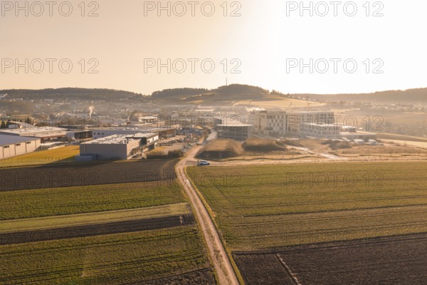 Extensive landscape with fields and buildings captured in low sunlight, new hospital at Calw Health