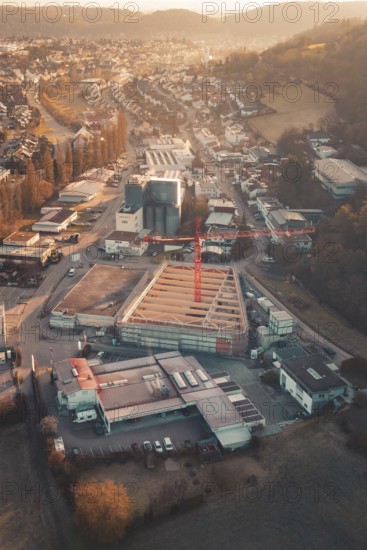 Aerial view of an urban building area with orange sky light and surrounding roads, Neubau Rewe,