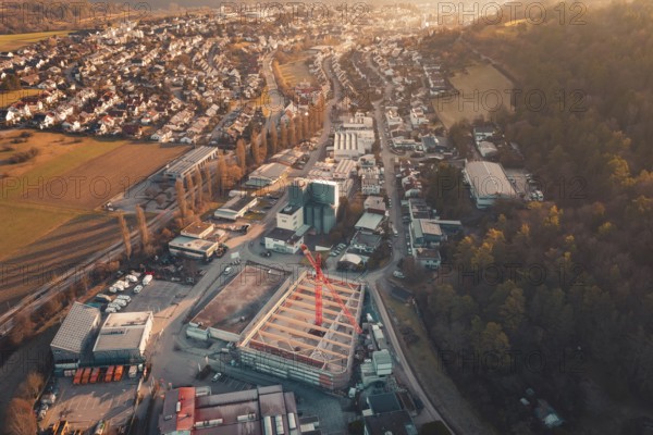 Panoramic view of an urban building area with crane and surrounding residential areas at sunset,