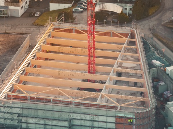 Close-up of a construction site with visible building structure and crane in warm light, Rewe new