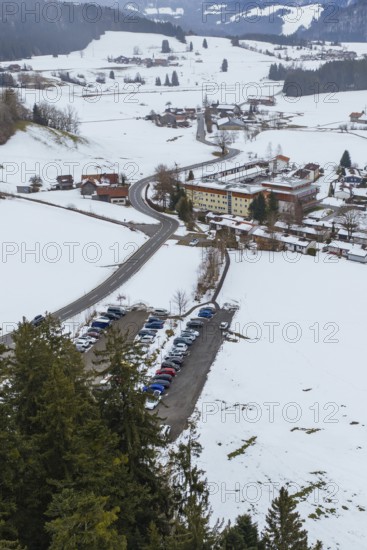 Snowy village with parking lots and picturesque mountains viewed from afar, specialist clinic for