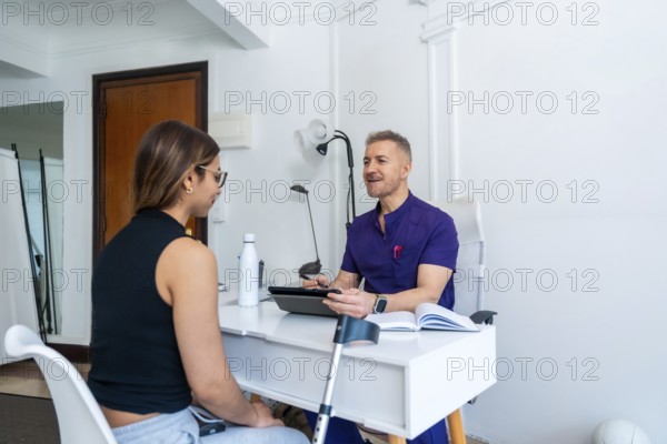 Healthcare professional wearing a uniform discussing medical recovery and sports osteopathy with a