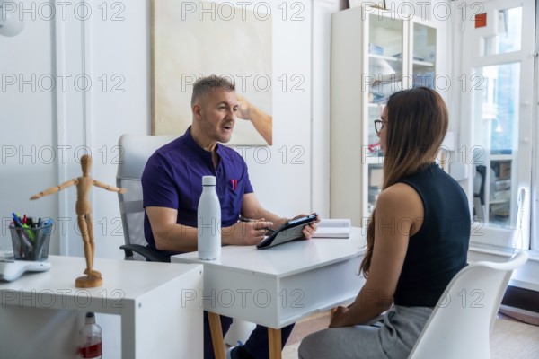 Medical professional wearing scrubs discussing therapy options and recovery plans with a female