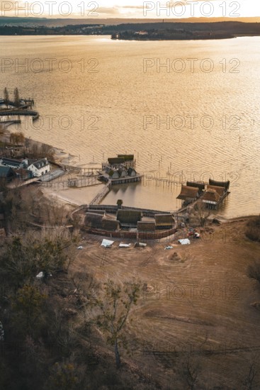 Traditional stilt houses on the water at a calm sunset, surrounded by natural beauty, stilt houses