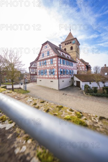 View of half-timbered houses and church tower with cobblestones and blue sky, Ötisheim, Enzkreis,