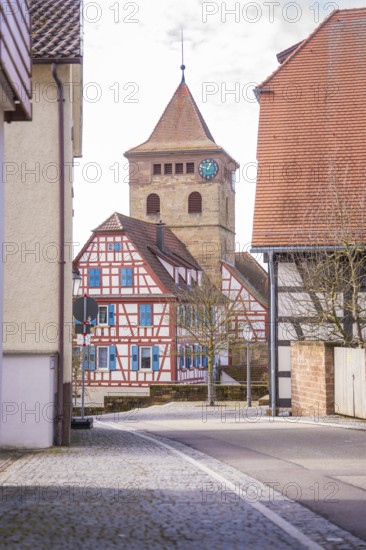 Street scene with view of half-timbered house and church tower with clock, Ötisheim, Enzkreis,