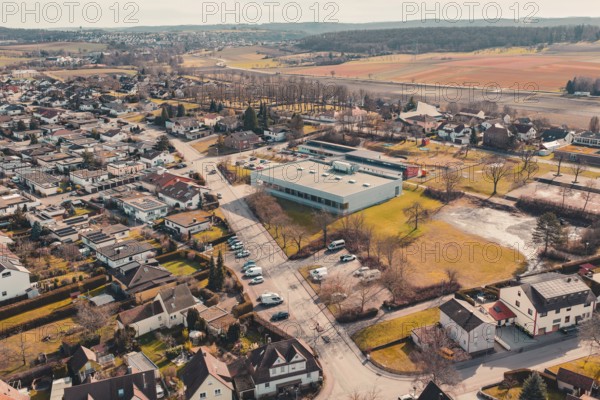 Bird's eye view of a village with buildings and natural fields in the background, Ötisheim,