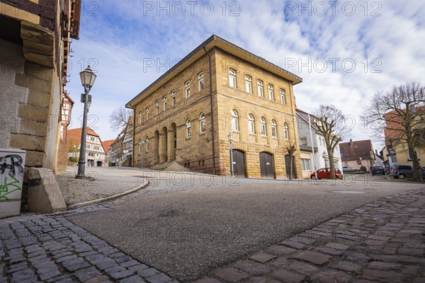 Historic building and wide cobblestone street with lanterns under blue sky, Ötisheim, Enzkreis,
