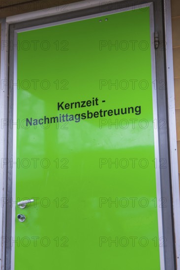 Green door with inscription for core time afternoon care, easy entrance, homework supervision,