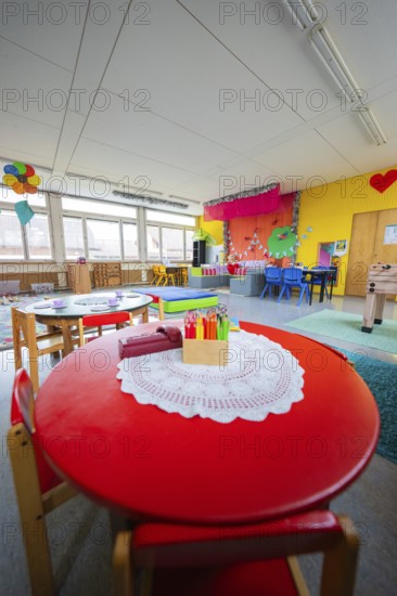 Creative environment in a kindergarten with round table and colored pencils, colorful decoration,