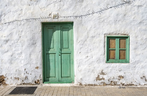 Typical white house with turquoise wooden door and window in an alley, Teguise, Lanzarote, Canary