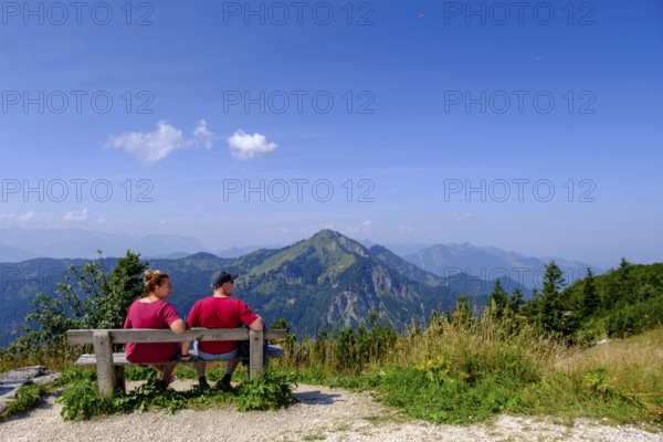 Hikers, mountaineers on a rest bench, in the summit area, at Hochfelln, near Bergen, Chiemgau,