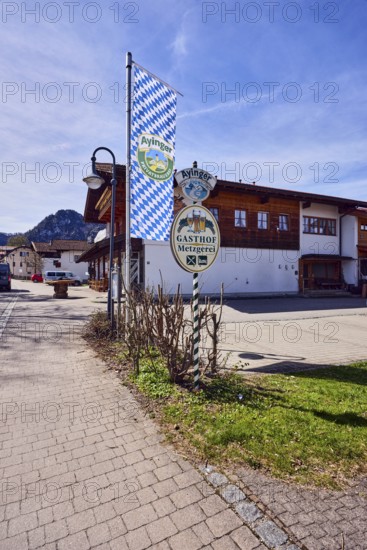 Privatbrauerei Ayinger, advertising flag on flagpole, Hirschbichler inn and butcher shop,