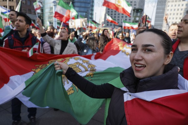 Iranians demonstrate with a large imperial Iranian flag on the day of the US and Israeli attack on