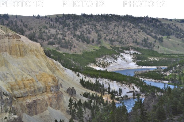 Wide landscape with a river snaking through wooded hills and steep cliffs, Yellowstone National