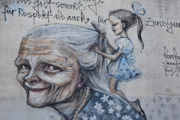 Mural from Herakut 2015, old woman with girl hairdressing her long hair, cosmetics, saying, face,