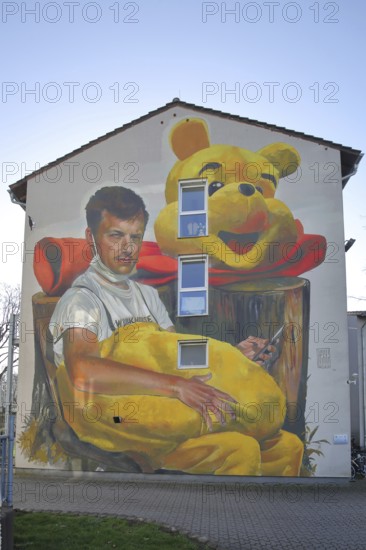 Mural Waldsterben by CASE MaClaim 2024, man with yellow plush toy, bear figure, street art,