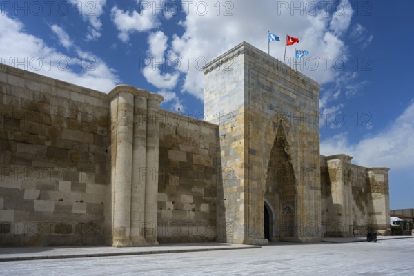 Historic stone architecture with massive gate and towers under a sunny sky, portal of the