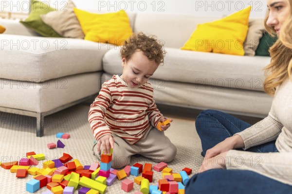 Young child with curly hair is sitting on the floor, deeply engaged in stacking colorful wooden
