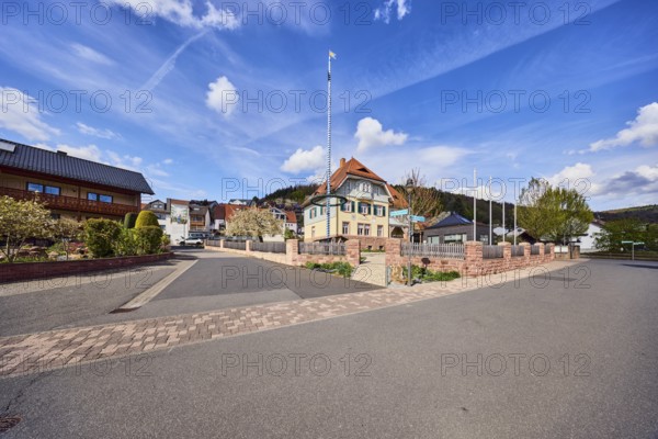 Town hall, maypole, flagpoles, roads, commercial buildings, residential buildings, single-family