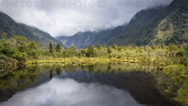 Peter's pool, glacier valley, mountains and glaciers in clouds. Westland Tai Poutini National Park,