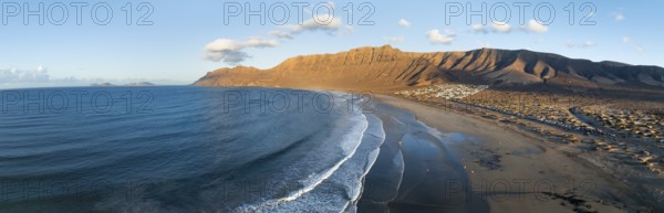 Panorama, Risco de Famara cliffs and sea with Famara beach, in the evening light, Playa de Famara,