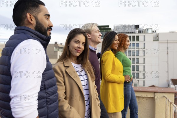 A cheerful group of friends enjoys a rooftop gathering, creating joyful memories with smiles and