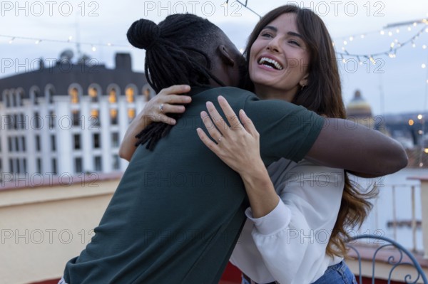 Two friends embrace joyfully on a rooftop, celebrating a party full of happiness and connection The