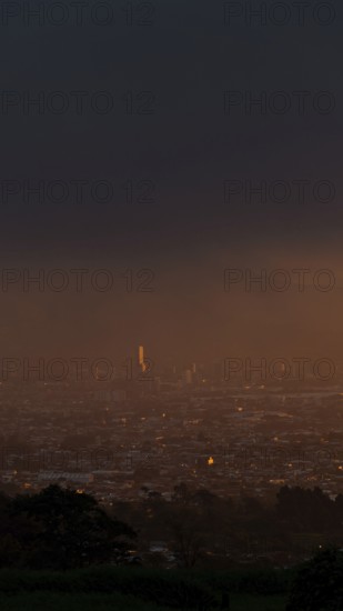 A serene sunset over San Jose, Costa Rica, captured from a mountain vantage point. The capital city