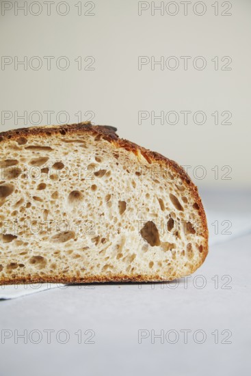 Close-up detail of a freshly cut slice of sourdough bread, showcasing its airy texture and crusty