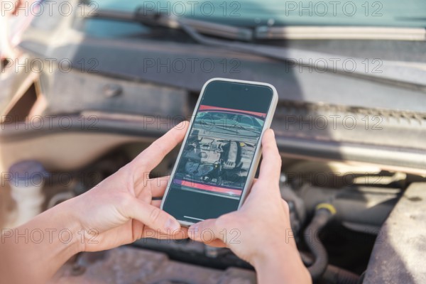 A person uses a smartphone to photograph car damage for insurance documentation The image