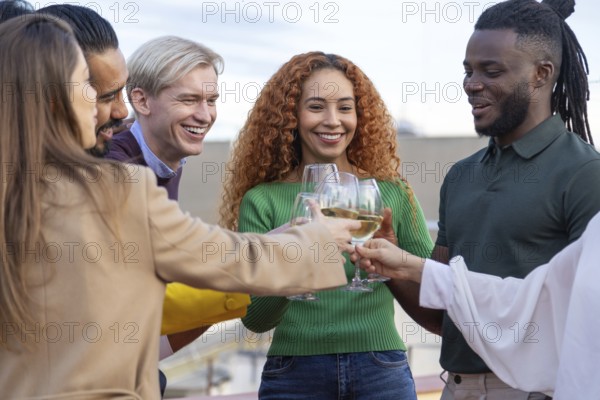 A joyful group of friends gather outdoors, sharing laughter and clinking glasses in celebration