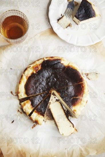 Top view of a minimalist photograph showcasing a freshly baked San Sebastian cheesecake, served on