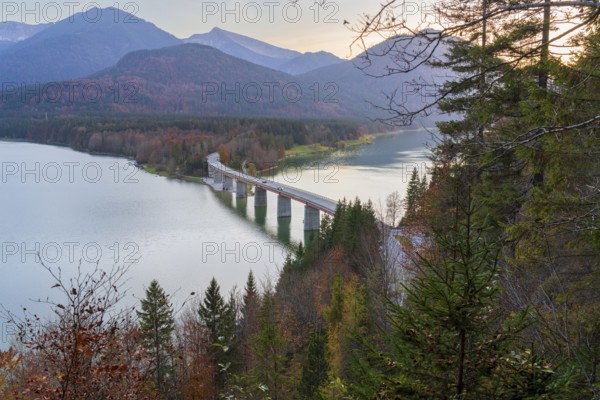 A scenic view of the Faller-Klamm Bridge spanning a tranquil lake in the Bavarian Alps Surrounded