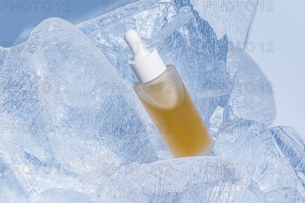 A skincare serum bottle nestled in sparkling clear ice, accentuating the concept of freshness and